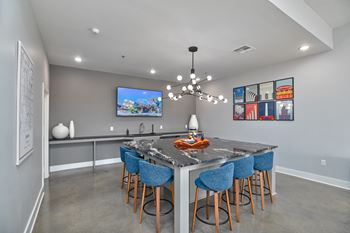 a kitchen with a marble counter top and blue bar stools